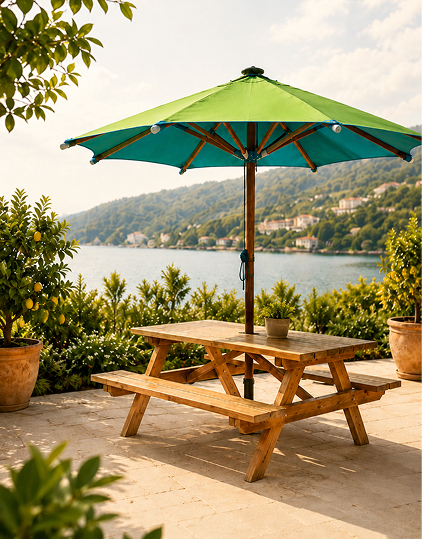 Parasol de exterior bicolor con estructura de madera sobre una terraza junto al lago, acompañado de una mesa de picnic y rodeado de vegetación mediterránea.